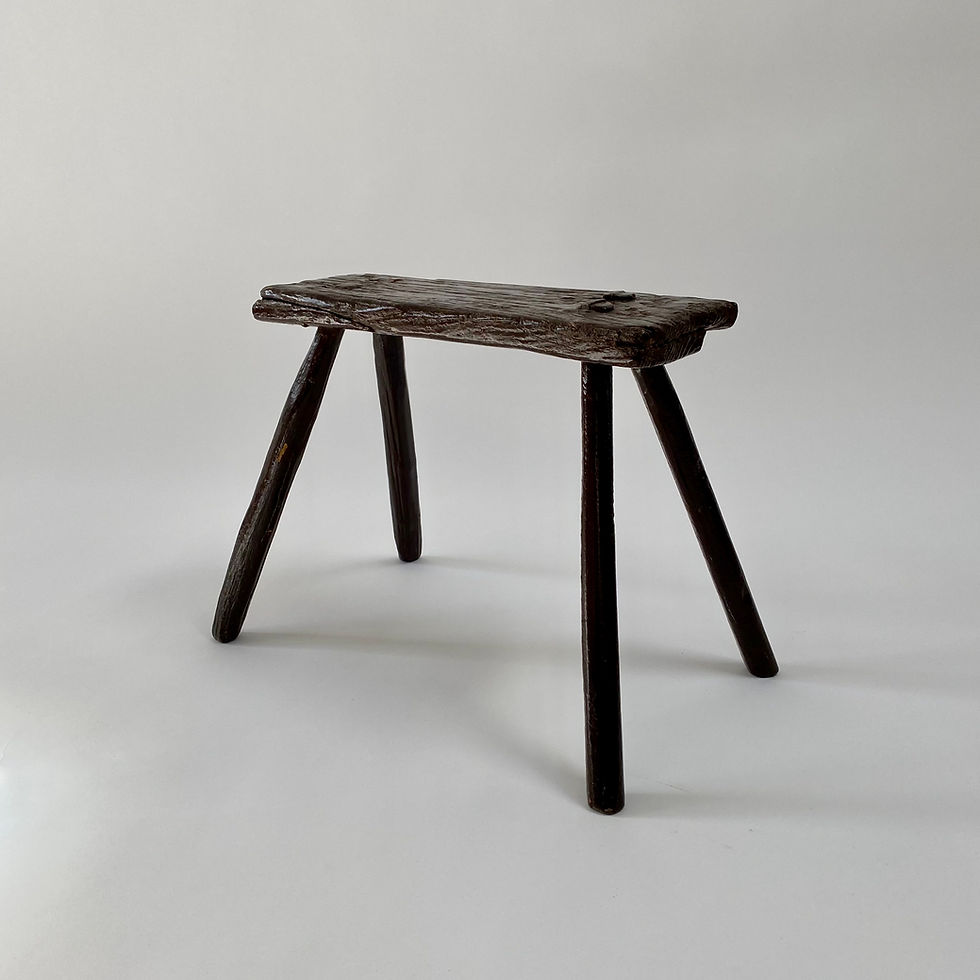 A small and charming primitive wooden stool with old brown paint