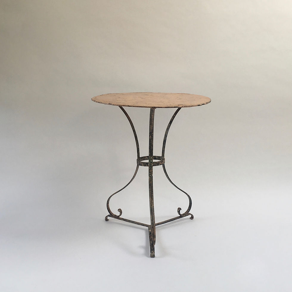 Vintage French bistro table in a shade of peach, with shapely wrought iron legs and a lovely patina