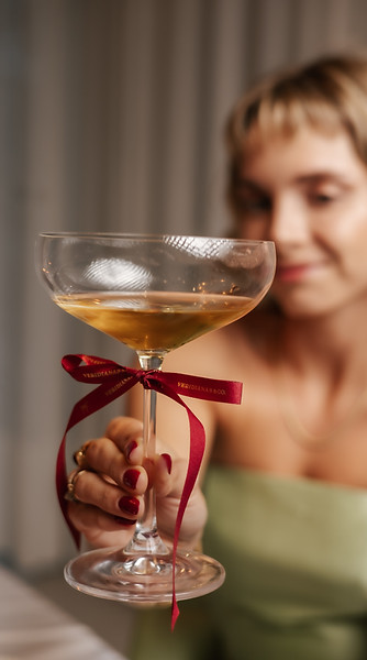 Mulher com taça de espumante em ambiente festivo — noivas Veridianas&CO em breve