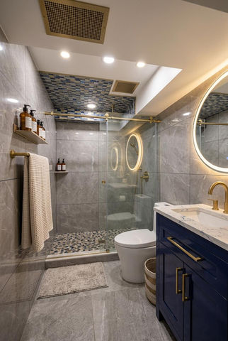 Modern bathroom with glass shower and circular mirrors.