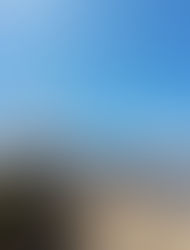 Hikers stand on rocky terrain with snow-capped mountains in the background under a clear blue sky, capturing a sense of adventure and vastness.