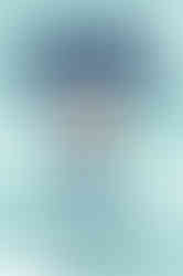 This image is the cover of a book titled "GAMER NATION" with the subtitle "Video Games & American Culture" by John Wills. The cover design has a strong retro video game aesthetic, reminiscent of 8-bit graphics from the early era of gaming. The central figure is a pixelated, white-haired Mario wearing a top hat with the American flag pattern, suggesting a play on the iconic Uncle Sam character. The character is running to the right and is mid-jump, as indicated by the white ascending pixelated cloud behind him, which is a common visual cue for movement in classic video games. The background is a plain light blue, with the title "GAMER NATION" prominently displayed in large, bold, blocky letters that span across the top half of the cover. The font choice for the title further reinforces the retro video game theme. The color scheme uses shades of blue, red, and white, which are colors of the American flag, connecting the theme of video games with American culture. The author's name, "John Wills," is positioned at the bottom of the cover in white text, ensuring it stands out against the blue background. Overall, the cover art is simple yet effective in conveying the subject matter of the book, which explores the relationship between video games and their influence on or representation within American cultural identity.