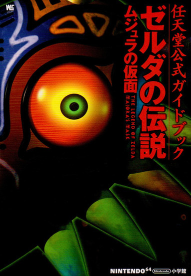 Japanese official guidebook cover for The Legend of Zelda: Majora’s Mask on the Nintendo 64. The close-up artwork features the ominous, glowing orange and green eye of Majora’s Mask, surrounded by its signature vivid colors and ornate design. Bold red Japanese text runs vertically along the right side, with the English title subtly embedded within. The cover exudes a mysterious and eerie tone, matching the game’s darker, time-driven narrative. The Nintendo 64 and publisher logos appear at the bottom.