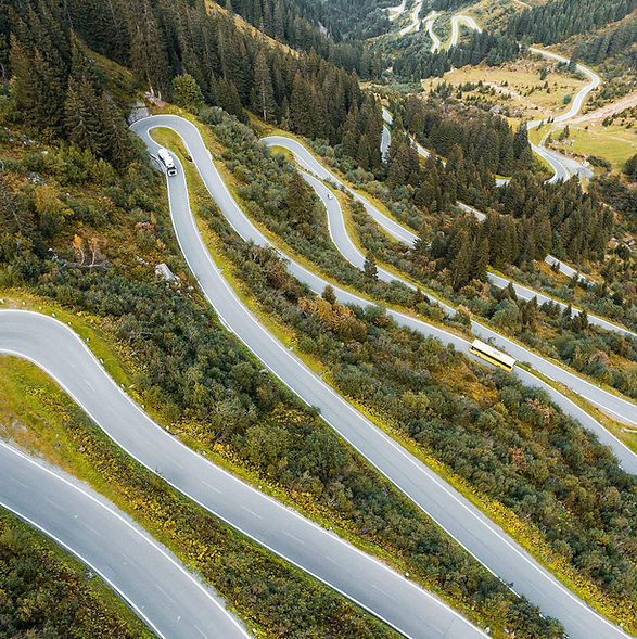Aerial view of a winding mountain highway passing through green hills