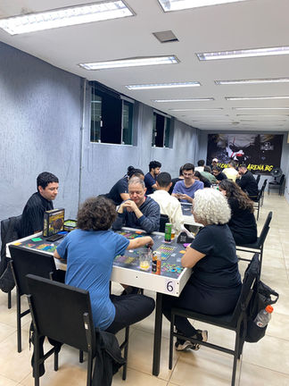 Pessoas jogando jogo de tabuleiro na Arena BG