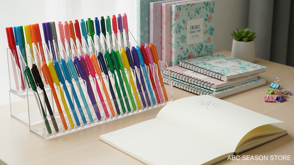Close-up view of colourful pens and notebooks arranged neatly on a desk