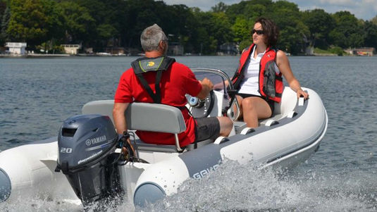 Man and woman in ATLANTIS boat, wearing life vests