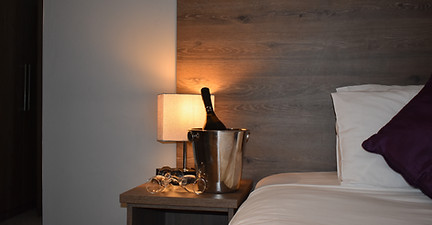 Champagne and glasses on hotel nightstand
