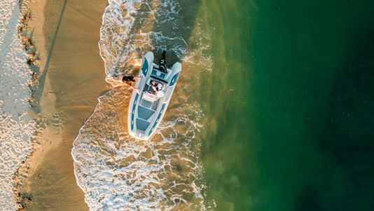 Atlantis boat on sandy beach with waves