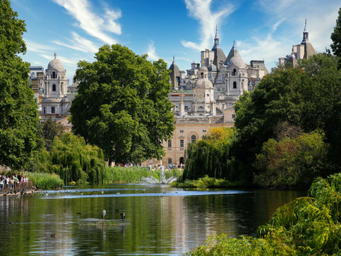 St. James's Park lake, London with historic buildings and lush trees.