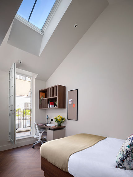 Bright room at Fifty One London with bed, desk, and skylight