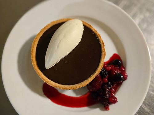 Chocolate tart dessert with ice cream and berries