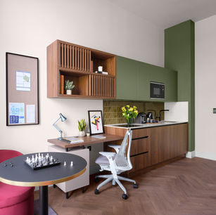 Modern studio apartment: desk, kitchenette, and seating area