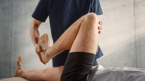 Physical therapist performing a knee stretch on a patient