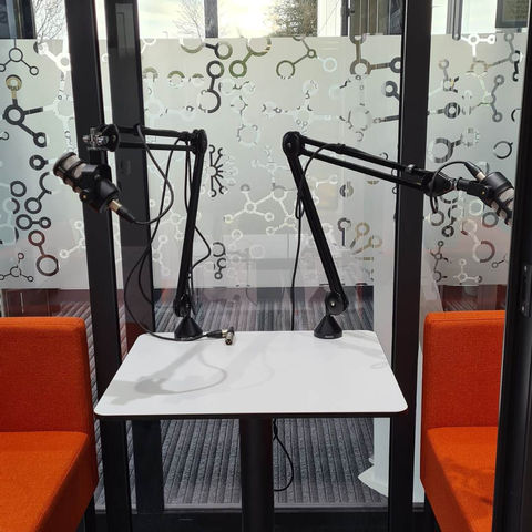 Podcast recording studio with two microphones and a white table