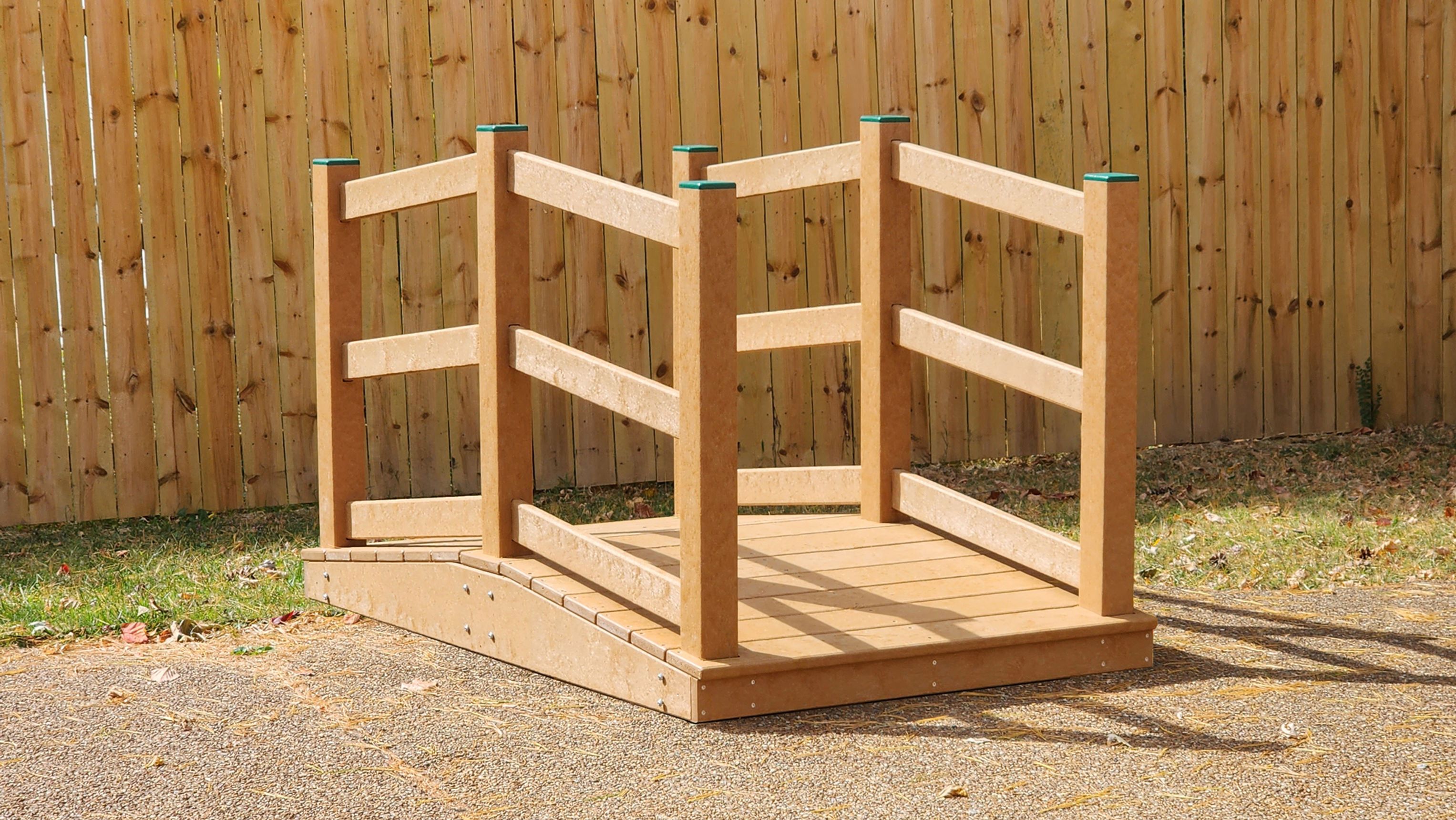 brown playground bridge with railings and post caps