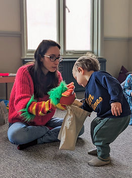 A teacher and a child playing with a puppet