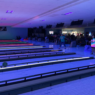 Cosmic bowling lanes with neon lights and bowlers