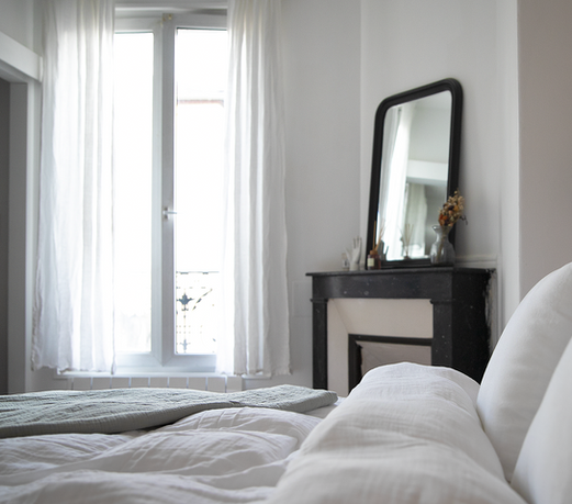 Chambre lumineuse, appartement parisien, cheminée ancienne, miroir trumeau