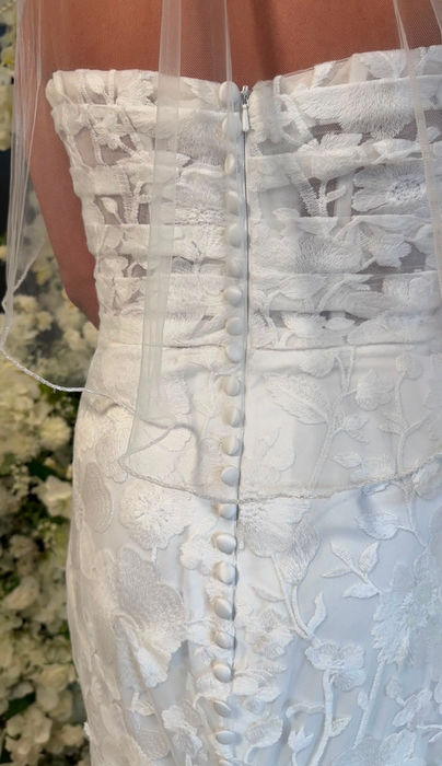 Cora by Mavery Hugh wedding dress size 8 ivory at Wedding Belles Love Stone Staffordshire featuring a fitted floral lace silhouette, straight neckline, delicate straps and structured corset bodice.