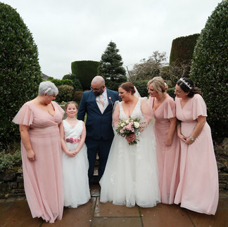 Bride walking through a rustic venue in her wedding dress smiling