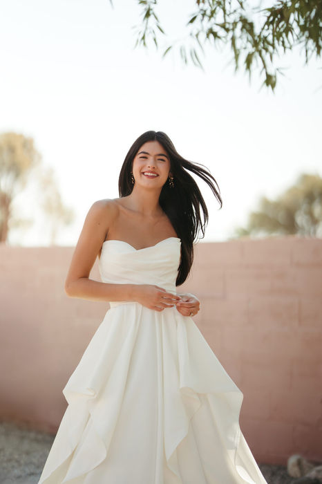 Stella York 8212 wedding dress at Wedding Belles Love featuring a strapless satin mikado bodice and elegant A line skirt with soft ruffle detailing, a timeless and modern bridal gown for contemporary brides