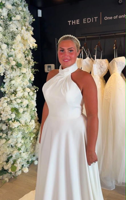 Marlene by Mavery Hugh wedding dress size 14 ivory at Wedding Belles Love Stone Staffordshire featuring a high halter neckline, open back and flowing A Line silhouette.