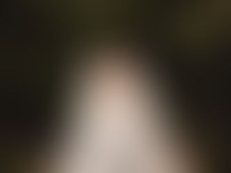 Two brides in wedding dresses holding hands and laughing, captured during their wedding day celebration.