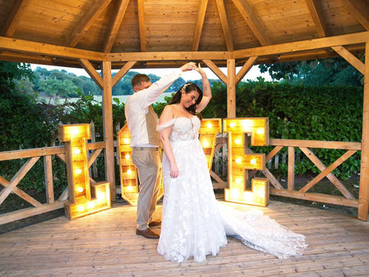 Bride wearing a modern lace A line wedding dress by Madi Lane with a square neckline and statement train.