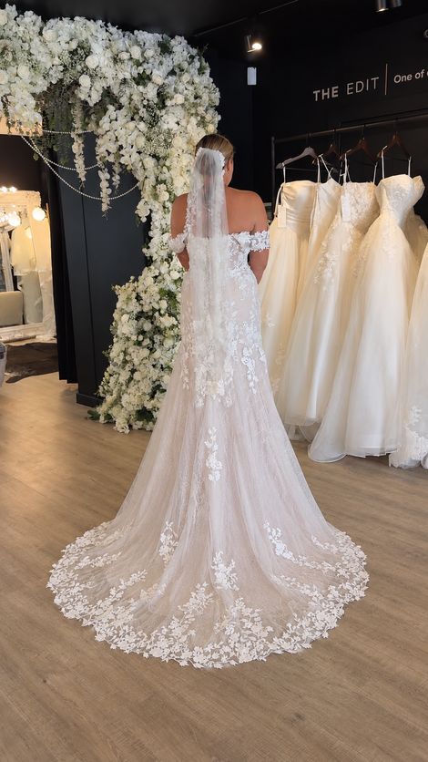 Lace wedding dress with shorter train and off the shoulder sleeves at Wedding Belles Love bridal boutique