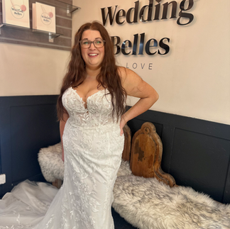 bride standing in natural light with her gown flowing softly around her.