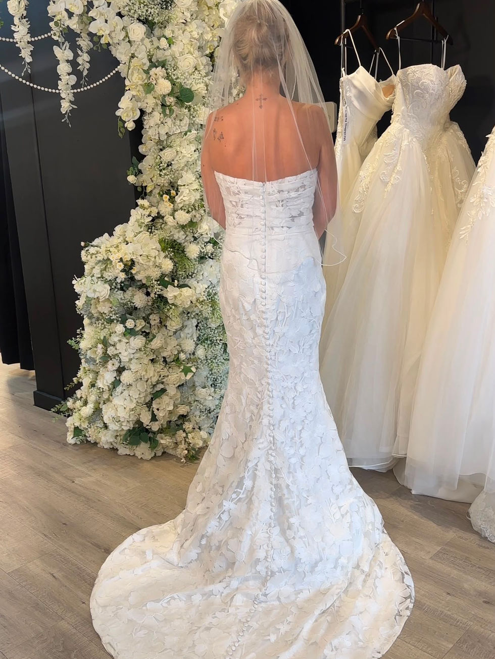 Bride wearing Cora by Mavery Hugh, an ivory fitted floral lace wedding dress with an illusion corset bodice, straight necklin