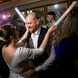 Candid wedding moment of bride laughing with guests photographed by Adam Lowndes