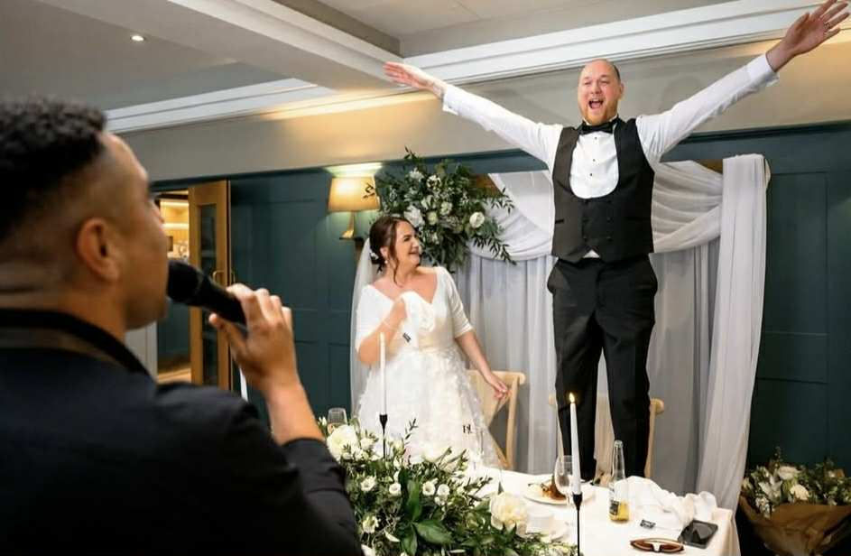 Candid wedding moment of bride laughing with guests photographed by Adam Lowndes