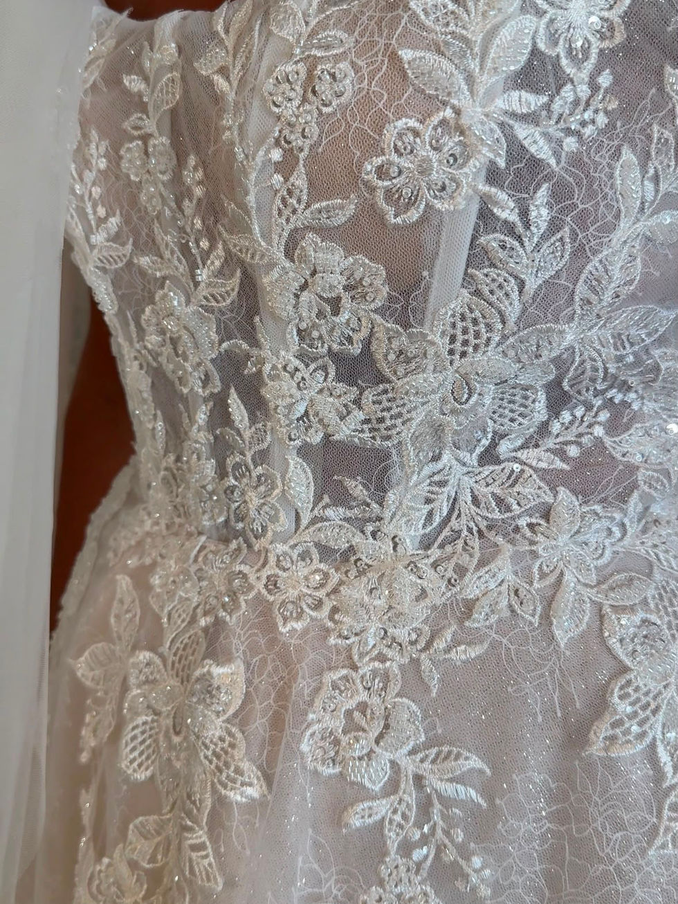 Bride wearing Bonnie by Mavery Hugh, an ivory sparkle A line wedding dress with an illusion corset bodice, sweetheart necklin