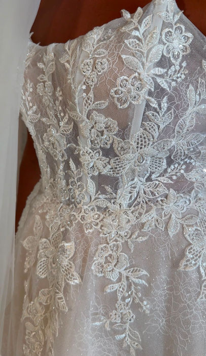 Bonnie by Mavery Hugh wedding dress size 14 champagne at Wedding Belles Love Stone Staffordshire featuring floral lace, glitter tulle and a structured corset bodice.