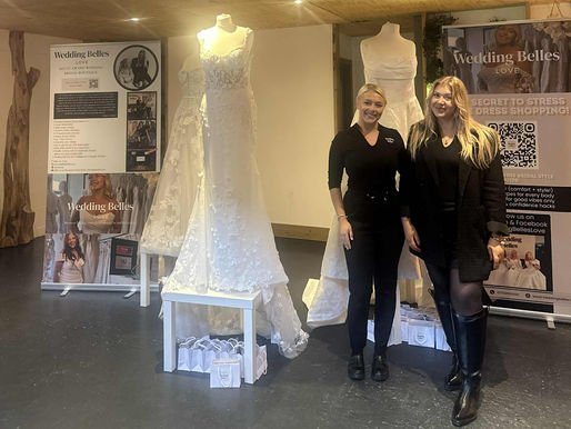 Wedding Belles Love stand at a wedding fair showcasing bridal gowns and accessories