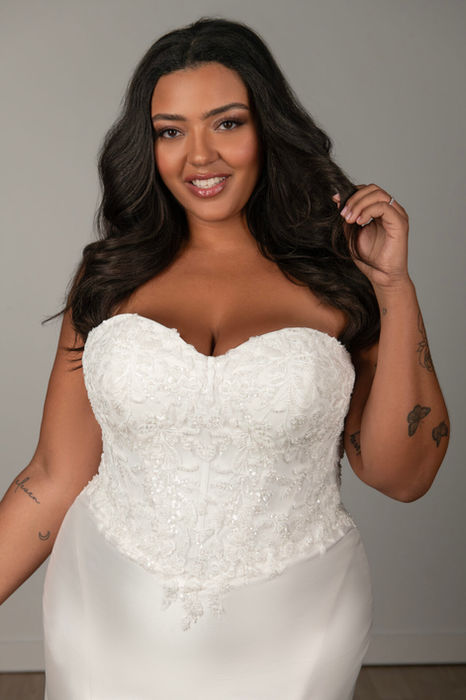 Stella York Style 8163 strapless fit‑and‑flare wedding dress in luxe Mikado and lace, featuring a corset‑inspired bodice with exposed boning, basque waist, lace‑trimmed trumpet skirt, and chapel train — plus‑size friendly, available at Wedding Belles Love, Claire Sutton’s size‑inclusive bridal boutique in Staffordshire
