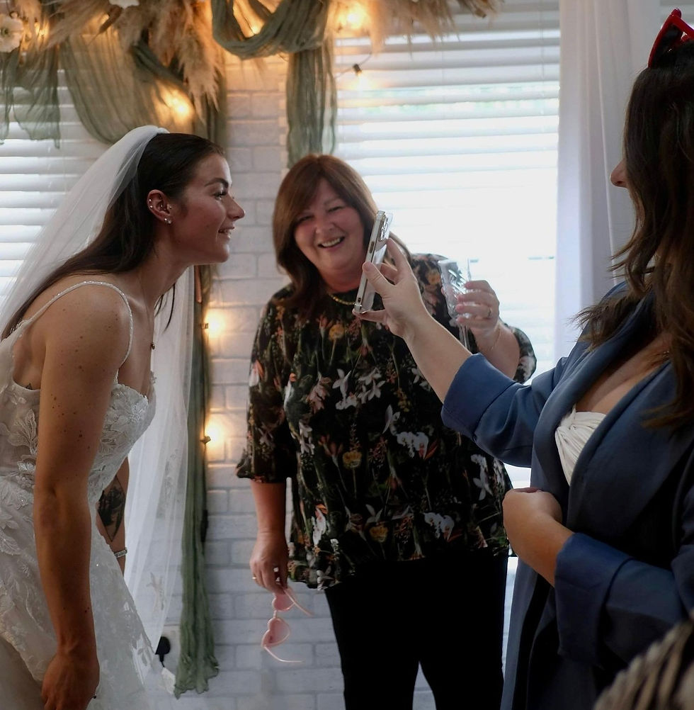 Bride getting ready for her wedding day while a makeup artist applies lipstick