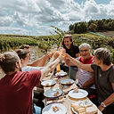 Repas convivial partagé entre amis autour d'une grande table dans les vignes