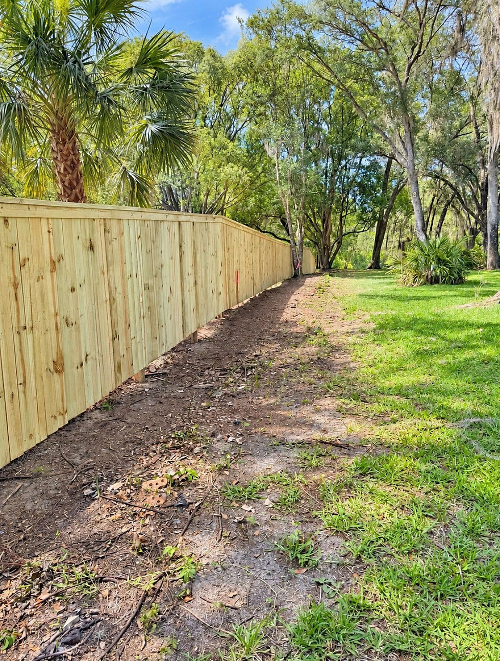 Wood fence with top board installation on residential property in Gainesville.