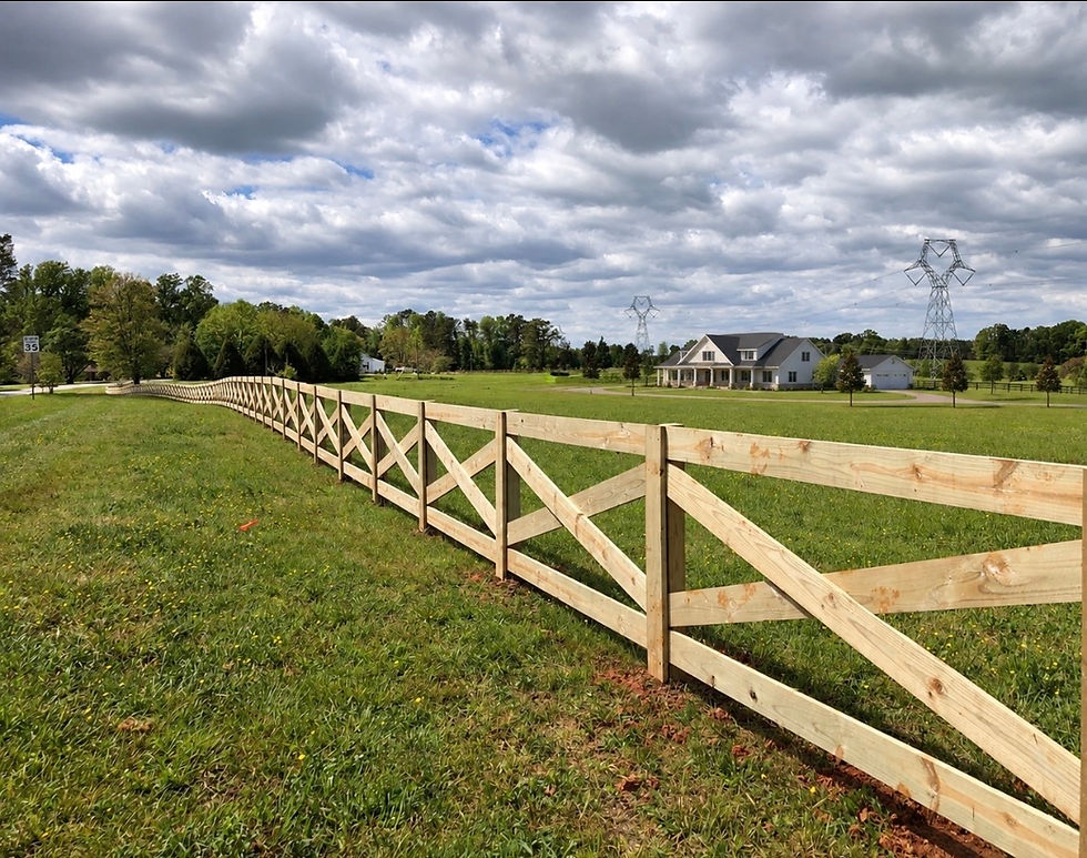 Wood crossbuck farm fence enclosing a large pasture
