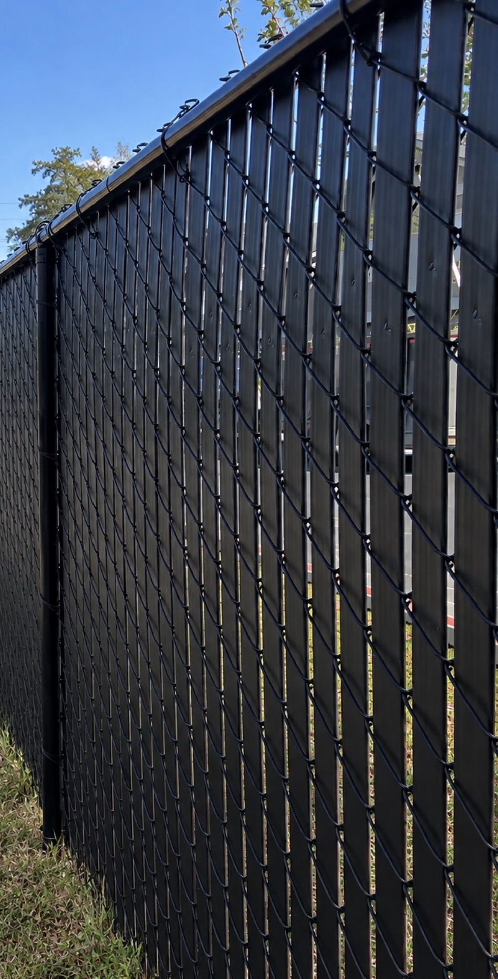 Black chain link fence with privacy slats for added screening
