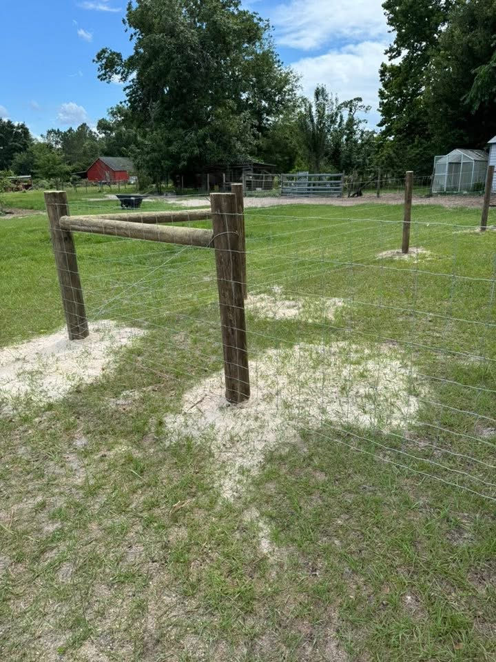 Woven wire farm fence with wood posts on a farm property