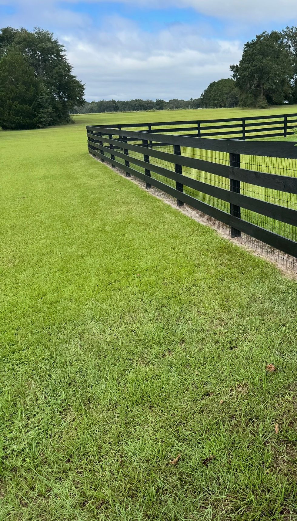 Restored and stained wood farm fence after fence restoration.