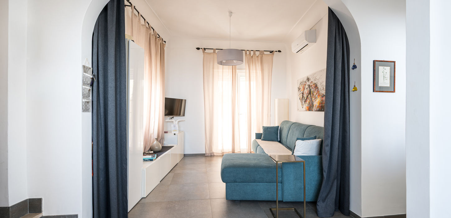 Ampio soggiorno per famiglie di Casa Leucosia con soffitti ad arco e grande divano blu