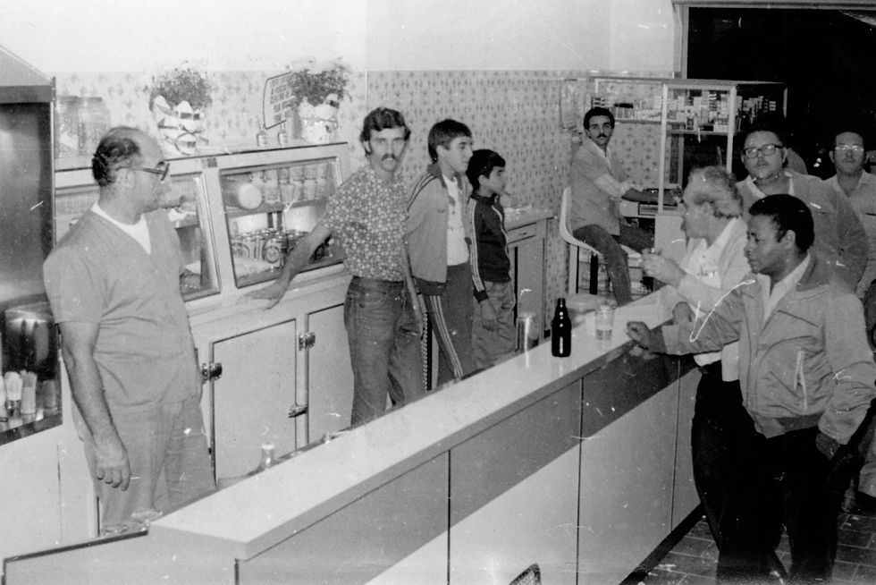 Gustão no interior do bar com seus filhos Odair, Almir e Airton (no caixa), aparecendo também os fregueses Muca, Dito Vanuci e Mário Bonato – década de 1970