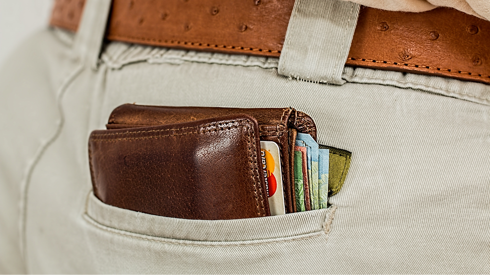 A brown filled wallet sticking out the back of light grey chinos