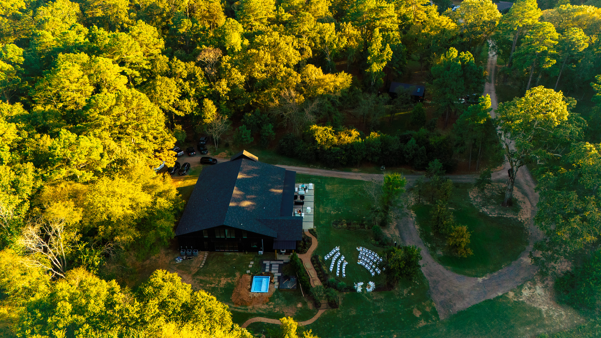 Aerial view of the wedding venue, ceremony lawn, and surrounding woodland