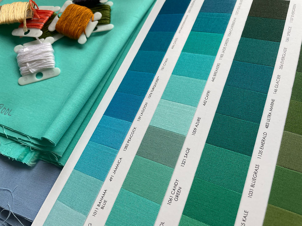 Close up of fabric color swatches, with the floss from the last photo piled on top.